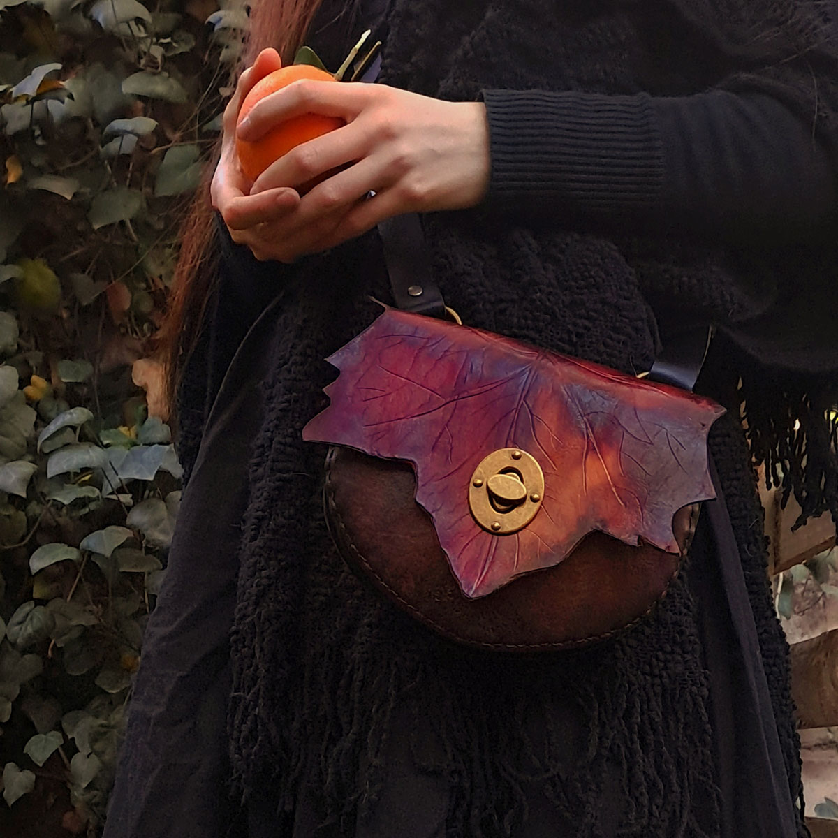 Bolso de cuero otoñal de tonos cafes y rojos con broche de cerrojo