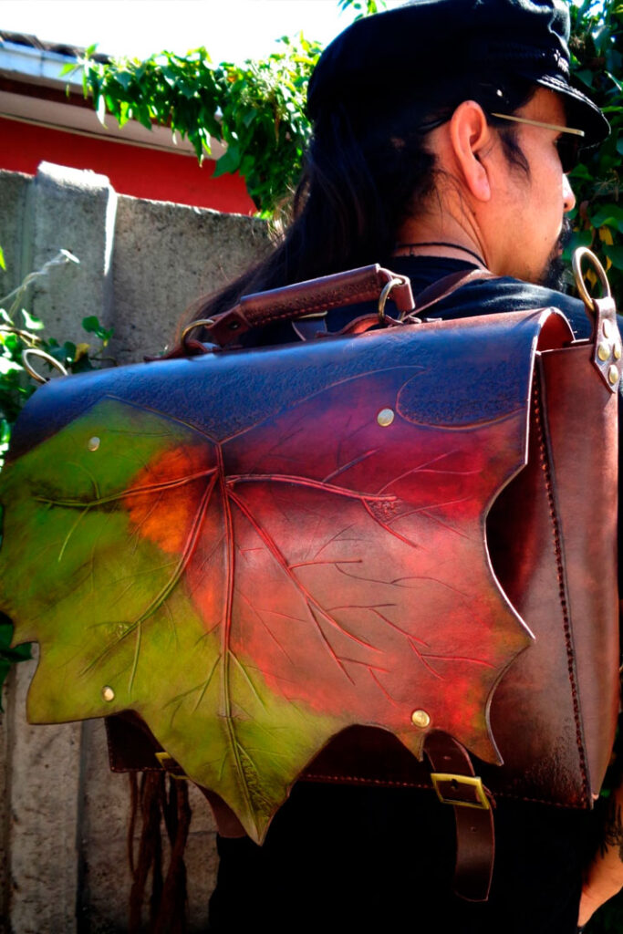 Foto de bolso de cuero, de espalda a la cámara sosteniendo el bolso.
Mirando hacia la derecha