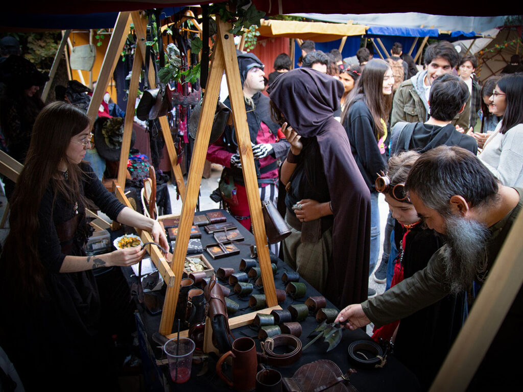Feria de mercado y juglares. Puesto con productos y clientes alrededor