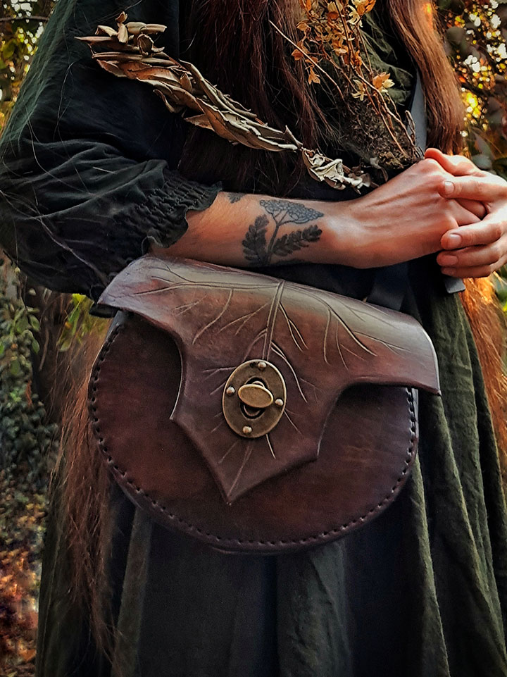 Bolso de cuero con forma de hoja con seguro metalico artesanal hecho a mano