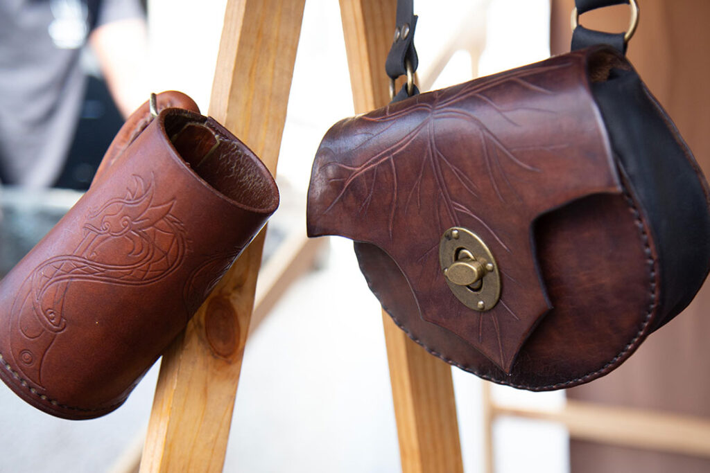 Bolso de cuero y tankard de cuero colgados para muestra