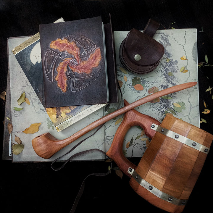 Libreta de cuero , tankard de madera , pipa de madera con monedero de cuero sobre un libre con mapa